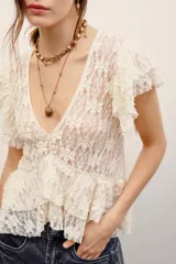 Camisa sin mangas de encaje blanco con escote en V y volados delanteros.