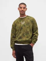 Buzo de cuello redondo, manga larga y calce holgado, color verde militar con estampado floral camuflado. Presenta el logo "GAP" bordado en el pecho en color blanco.