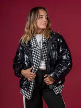Campera puffer negra de nylon con cuello alto y cierre frontal. Interior con estampado de pata de gallo en blanco y negro.
