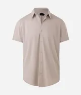Camisa de manga corta color beige, con cuello camisero, cierre frontal de botones y diseño liso.