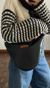 Bandolera negra de cuero sintético con textura tipo cocodrilo y correa ajustable.