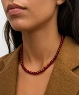 Collar de cuentas esféricas de vidrio pulido en color rojo intenso, con cierre metálico bañado en oro 18k.