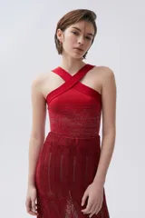 Top de tiras cruzadas color rojo. Su cuerpo tejido se amolda a la silueta y las tiras cruzadas permiten tener los hombros al descubierto, sujetando bien el busto.