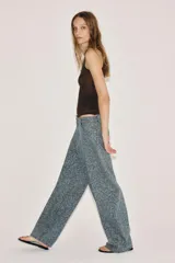 Jeans de tiro medio con corte barrel, confeccionados en denim con estampado floral integral. Presentan diseño de cinco bolsillos, cintura con trabillas y cierre frontal con cremallera y botón.
