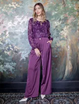 Pantalón palazzo de satén con tiro alto, pretina con pasadores, cierre y botón frontal, y elástico en la parte trasera. Cuenta con bolsillos laterales verticales.