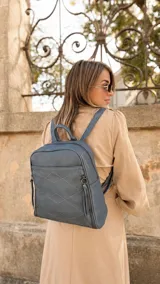 Mochila de diseño estructurado en color bordó, confeccionada en símil cuero con costuras decorativas en forma de rombos en el frente. Cuenta con un bolsillo frontal con cierre, asa superior de mano y correas regulables.