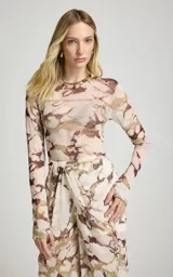 Blusa de manga larga confeccionada en tul semitransparente con estampado abstracto en tonos marrones y beige, cuello redondo y calce ajustado.