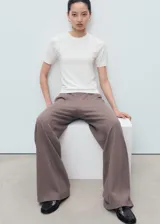 Pantalón de corte recto y largo, color marrón, con cintura elástica sin cierre y bolsillos laterales.