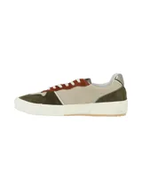 Sneaker de diseño moderno que combina cuero liso y texturado en tonos verde oliva, beige y detalles en color terracota. Presenta cordones blancos y un detalle metálico en el talón, con una suela de goma blanca de estilo plataforma.
