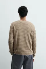 Jersey relaxed fit de cuello redondo y manga larga, con diseño de rayas horizontales y acabados en rib.