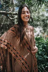 Ruana de algodón color beige con intervención de hilado de cuero de napa ovina color negro. Diseño artesanal con calados geométricos.