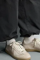 Zapatilla de estilo retro con cordones y efecto desgastado, confeccionada en una combinación de materiales con detalles de piel con acabado serraje y suela de goma a contraste.