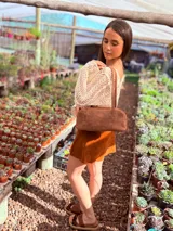 Cartera baguette de cuero color marrón con forro interno de tela.