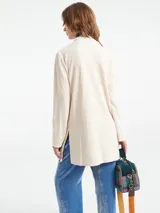 Chaqueta color crema de pana con cuello mao, cierre con botones y bolsillos frontales.