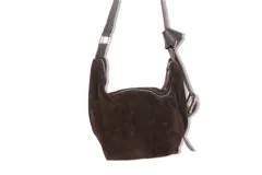 Cartera bandolera de gamuza marrón con correa ajustable de cuero y cierre superior con cremallera.