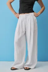Pantalon blanco de lino de pierna ancha y tiro alto, con pinzas frontales y bolsillos laterales.