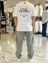 Remera blanca oversize con estampado gráfico en la espalda con la inscripción "Valley of Stars", diseño de manga corta y corte holgado.