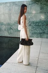 Jean de tiro alto y piernas amplias, color crudo, confeccionado en denim de algodón rígido, con detalles de bordado estilo crochet tono sobre tono en los laterales.