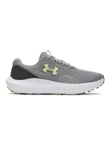 Championes de running Under Armour Charged Surge 4, color gris con detalles en verde lima y blanco. Presentan una parte superior de malla transpirable con refuerzos sintéticos, entresuela Charged Cushioning para mayor amortiguación y suela de goma resistente.