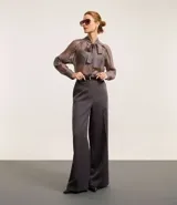 Pantalón de sastrería de corte recto y tiro alto, con diseño de pierna ancha, trabillas en la cintura, cierre frontal con botón y cremallera, y bolsillos laterales con costuras verticales.