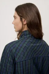 Campera liviana de calce relajado con estampado a cuadros en tonos de azul y verde. Cuenta con cuello alto, cierre frontal y mangas largas.