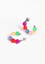 Aros tipo argolla de acero quirúrgico hipoalergénico con cuentas de acrílico de colores.