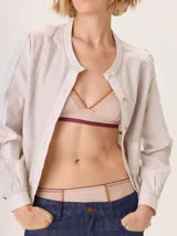 Conjunto de ropa interior compuesto por un soutien triangular y una bombacha, confeccionado en una mezcla de poliamida y elastano. Presenta detalles de puntilla, pespuntes a contratono y una combinación de texturas en tonos nude con acentos en color bordó.