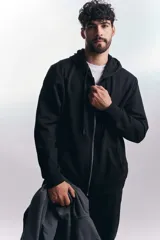 Campera deportiva negra con cierre frontal y capucha con cordones ajustables.