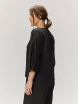 Blusa roja de manga larga con volumen sutil en las mangas y diseño holgado, confeccionada en algodón.