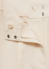 Pantalon de vestir de corte recto y tiro alto, color beige, con detalle de pinzas frontales, bolsillos laterales y cierre oculto.