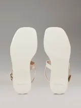 Sandalias Calvin Klein de goma color crema, con tira delantera y tira trasera ajustable con hebilla.