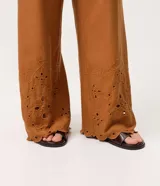 Pantalón pantacourt de Marfinno, color tostado, de corte amplio y cintura ancha. Con detalles de bordado calado tipo broderie y terminación ondulada en el bajo.
