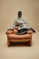 Chaqueta de corte holgado con estampado de cuadros, cuello subido, manga larga con puños elásticos y cintura ajustable mediante cordones. Presenta bolsillos delanteros con solapa y cierre frontal con cremallera oculta y botones a presión.