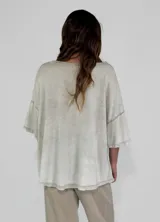 Remera de algodón con efecto lavado, color naranja, de corte oversize, cuello redondo y mangas cortas. Presenta una abertura lateral con botones decorativos.