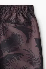 Short de baño con estampado de hojas en tonos oscuros, cuenta con cintura elástica con cordón ajustable, bolsillos laterales y un bolsillo trasero. Incluye suspensor interior de malla.