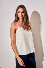 Musculosa blanca de viscosa con tirantes finos, escote en V y detalle de bordado floral con recortes en el borde superior.