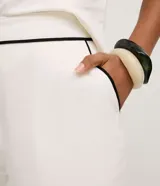 Short Marfinno de viscolino color blanco, con cintura elástica, bolsillos simulados en la parte trasera y ribetes en contraste negros.