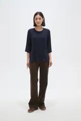 Remera de viscosa en color verde oliva, con cuello redondo y mangas 3/4. Presenta un diseño de tejido acanalado y corte holgado.