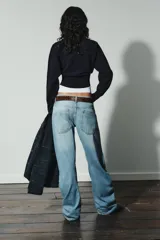 Jersey de punto liso con diseño cropped, cuello redondo y manga larga. Presenta acabados en rib en cuello, puños y bajo.