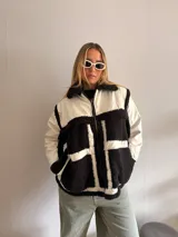 Campera con cuerpo de corderito negro y detalles en blanco.