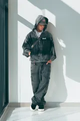 Pantalón tipo cargo de corte ultra baggy, confeccionado en denim de algodón con efecto lavado desgastado. Presenta bolsillos laterales tipo cargo y diseño de pierna ancha.
