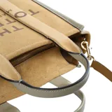 Cartera tipo tote bag de Marc Jacobs, confeccionada en una combinación de cuero gamuzado color tostado y cuero texturizado marrón. Presenta el logo estampado en el frente, doble asa superior y correa ajustable extraíble.
