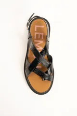 Sandalias negras de cuero con tiras entrelazadas en el empeine, suela flatform dentada y tira ajustable con hebilla en el talón.