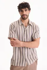 Camisa de manga corta de tejido jacquard con estampado de rayas verticales en tonos beige y gris. Presenta cuello camisero clásico y cierre frontal de botones.