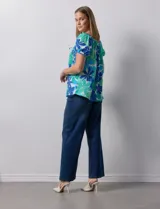 Blusa de seda fría con estampado floral en tonos azules y verdes. Cuello redondo con frunce y mangas cortas amplias con terminación fruncida.