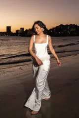 Pantalón palazzo de satén color blanco, fluido y con cintura elástica. Presenta detalle de plumas en la cintura.