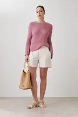 Sweater de punto fino en color verde, con cuello redondo y mangas largas. Presenta un detalle integrado de pañuelo estampado con motivos florales en la parte inferior, que se cruza sobre la cintura.