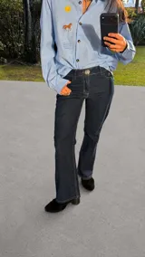Pantalón de jean azul oscuro de tiro bajo, corte recto y cierre con botón metálico.