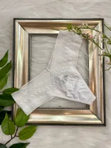 Bombacha blanca tipo tanga de algodón con encaje en la cintura.