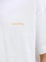 Remera blanca de manga corta, corte holgado y cuello redondo, con pequeño estampado en el pecho.